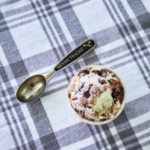 Moose Tracks ice cream scoop next to a bowl of ice cream