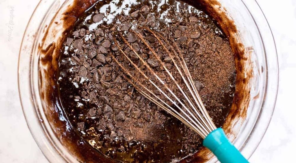 brownie batter in a bowl with a metal spatula
