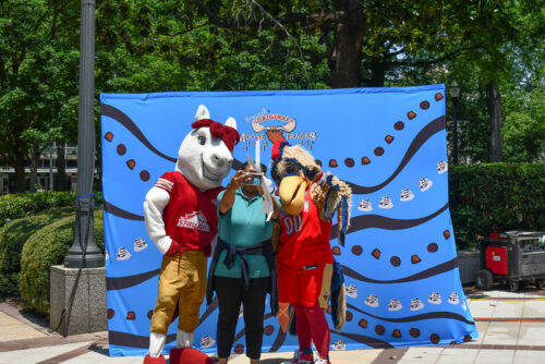 Event attendee snaps a photo with local sports mascots