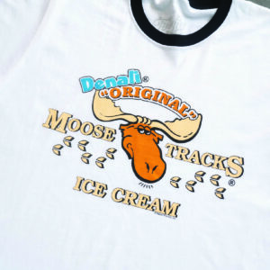 white t-shirt with black ringer banding around neck and arms. features moose tracks ice cream logo