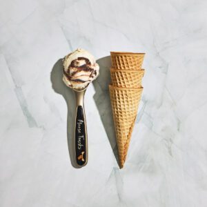 Moose Tracks labeled ice cream scoop with a scoop of Moose Tracks Ice Cream and stack of three waffle cones.