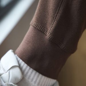 A close up image of the ankle of brown sweatpants