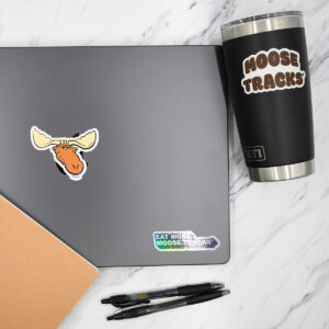 A laptop and a black travel tumbler decorated with Moose Tracks stickers