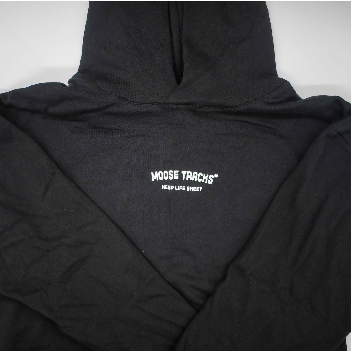 A close-up image of the front of the Moose Tracks Keep Life Sweet Hoodie. The sweatshirt is black with the words "Moose Tracks" and "Keep Life Sweet" in screen-printed white text on the chest.